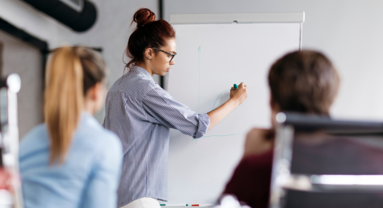 Woman drawing graph on whiteboard