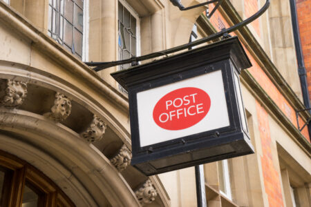 post office sign hanging above stone doorway