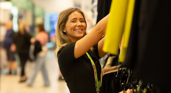 asda worker stacking clothes shelves