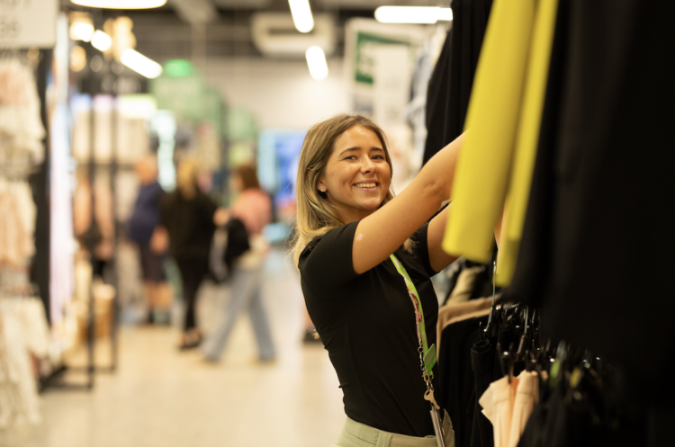 asda worker stacking shelves with clothes