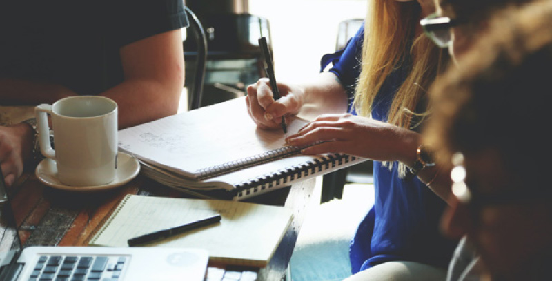two people writing in a cafe
