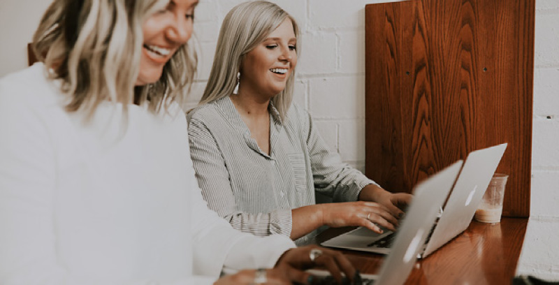 team workers on macbooks smiling