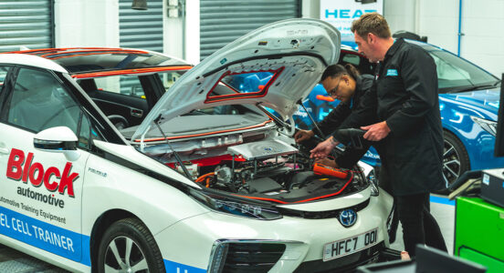 two mechanics working on a hydrogen powered car in a garage